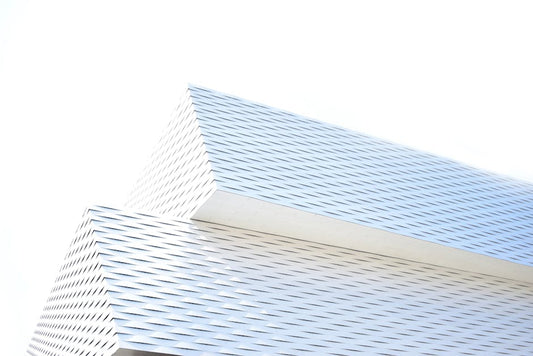 Digital artwork of overlapping white and blue architectural structures with a woven texture, symbolizing the fusion of minimalist design and artistic expression in modern environments.